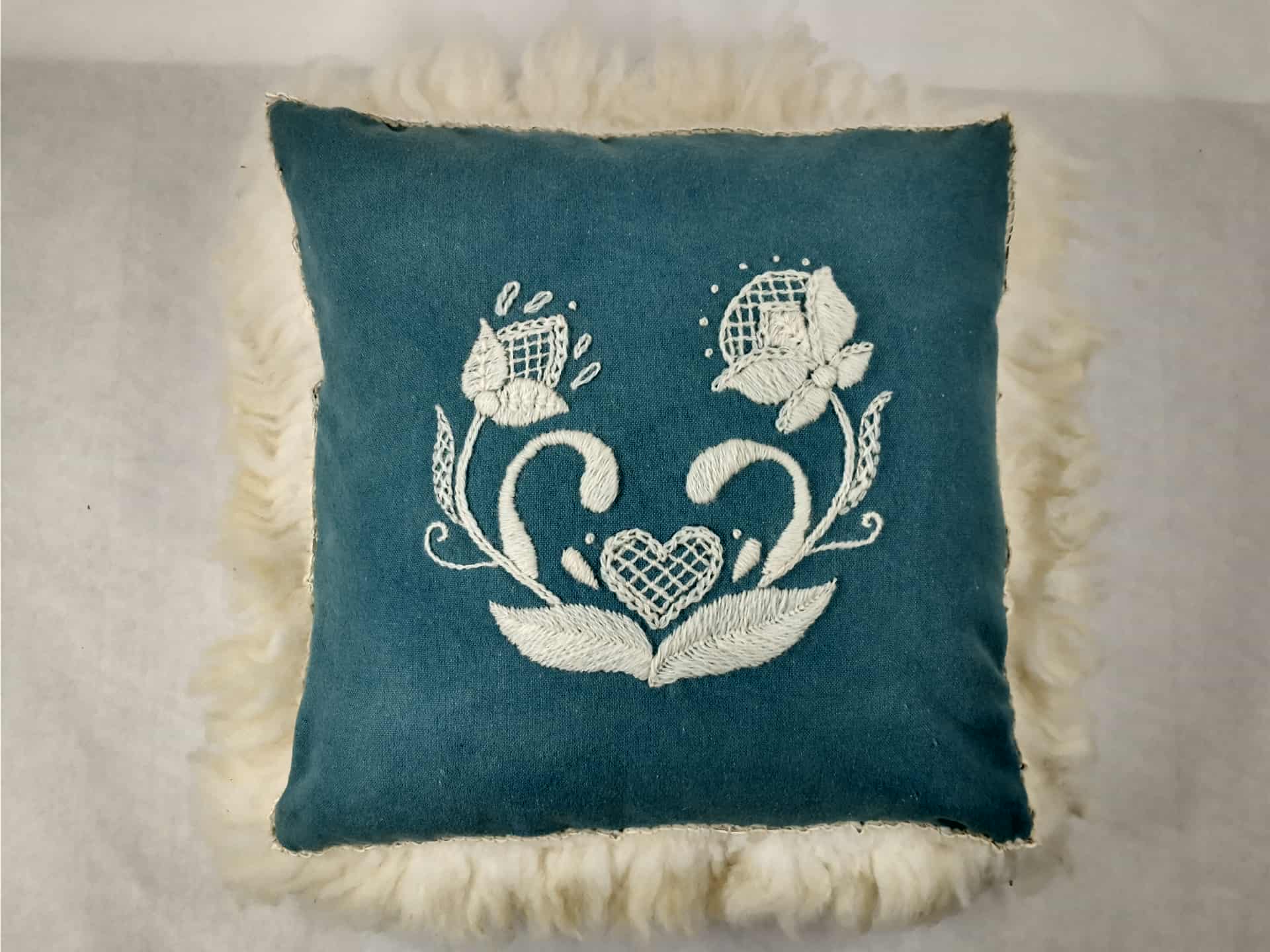 teal embroidered pillow